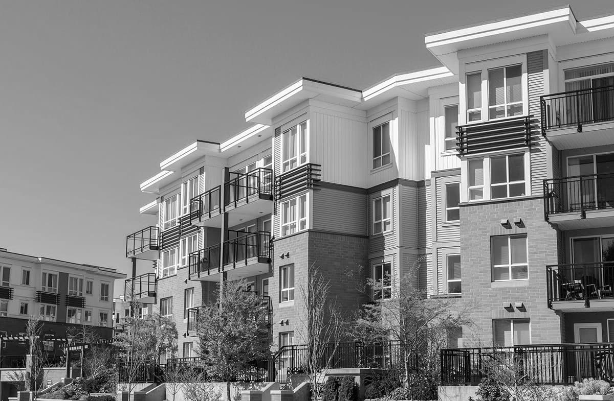 Mid-rise apartment building with balconies under a clear sky